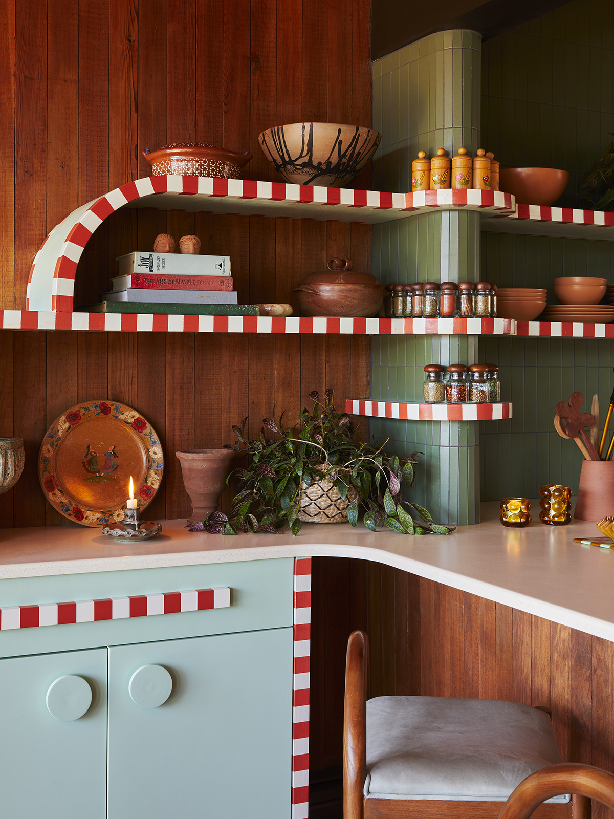 Kitchen shelving with wood-paneled walls and candy striped open shelving