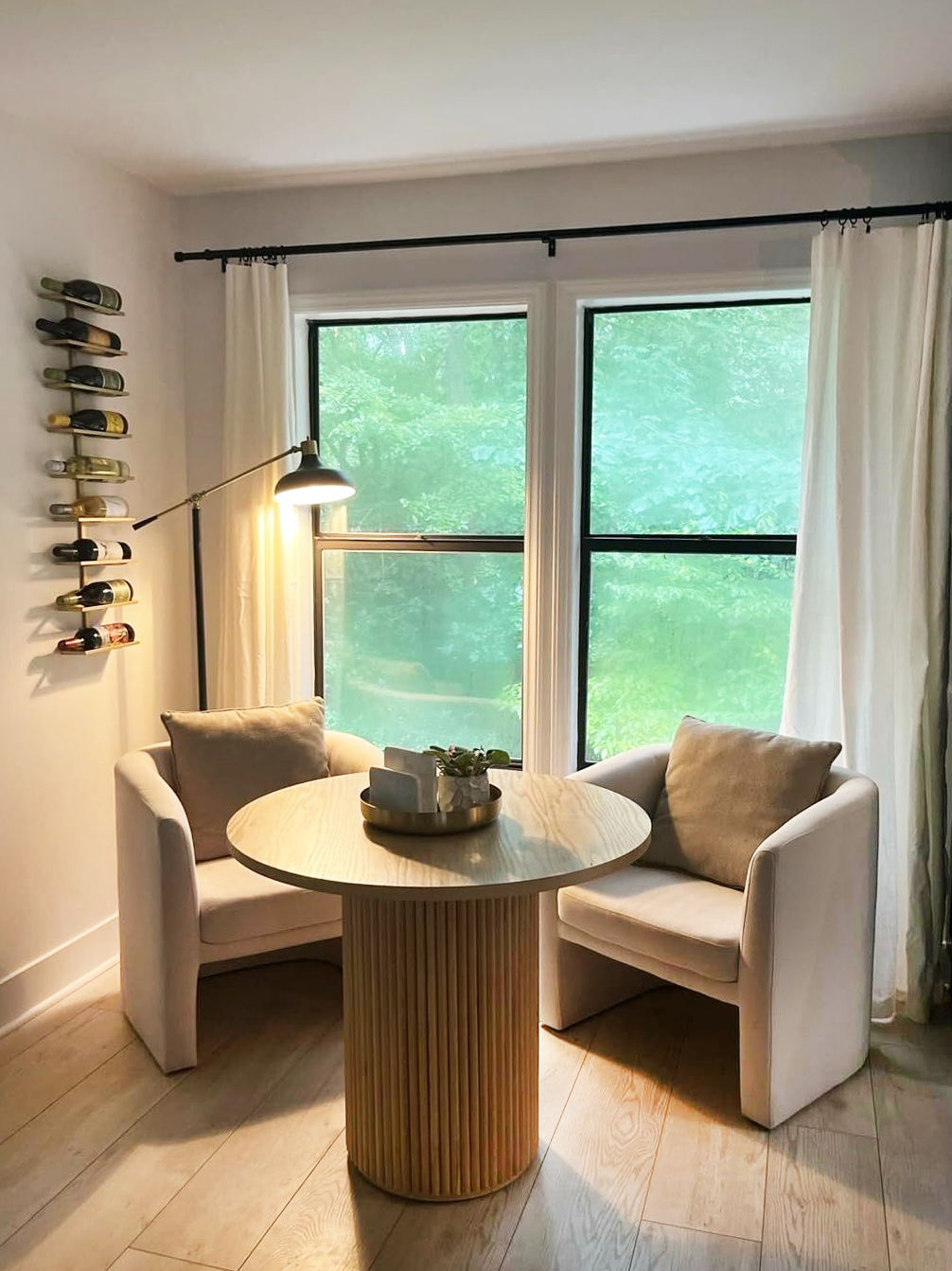 round dining table in corner of home flanked by two upholstered arm chairs