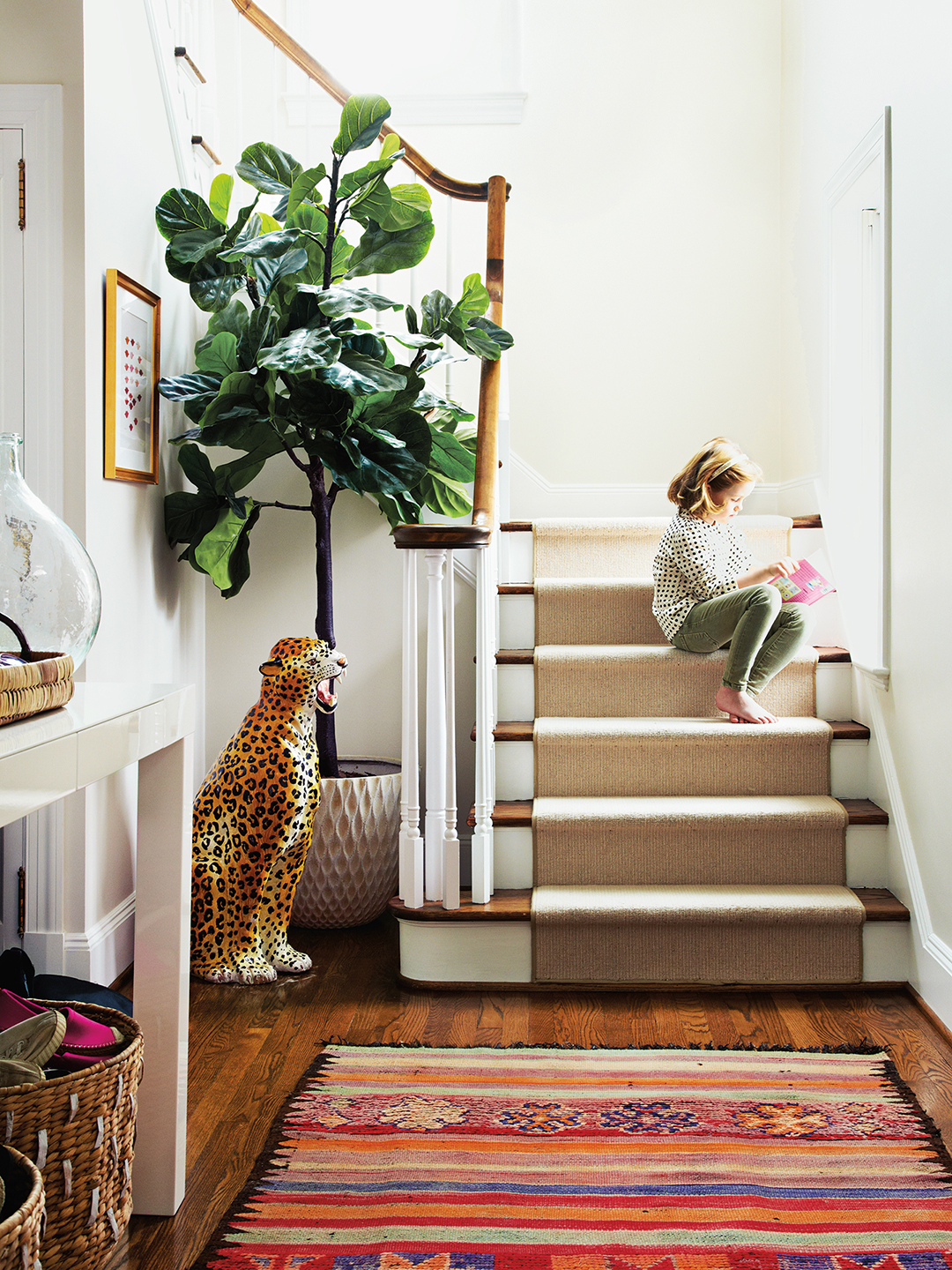 Kid sitting on stairs with leopard statue next to them