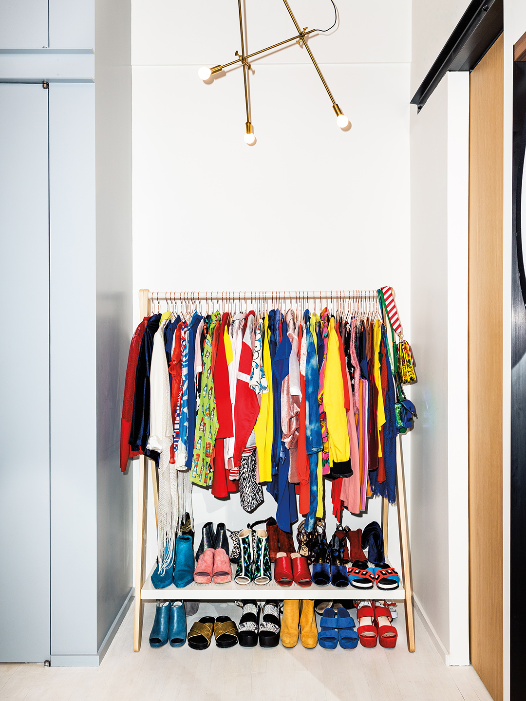 Hanging rack with brightly-colored clothes and shoes