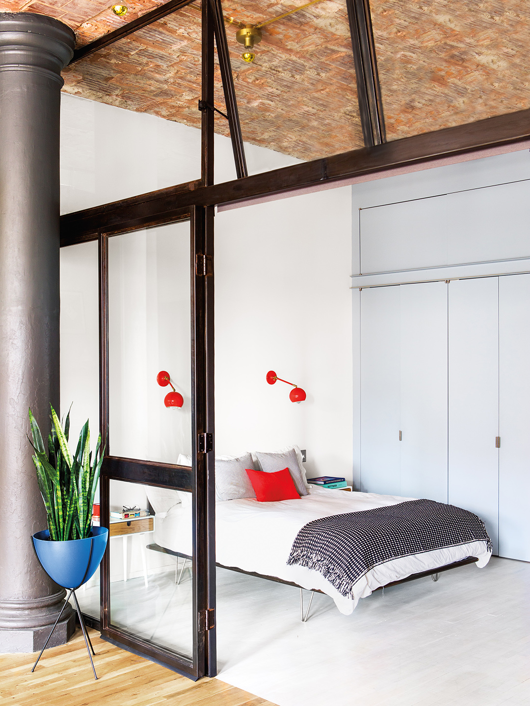 Bedroom with red sconces and red pillow