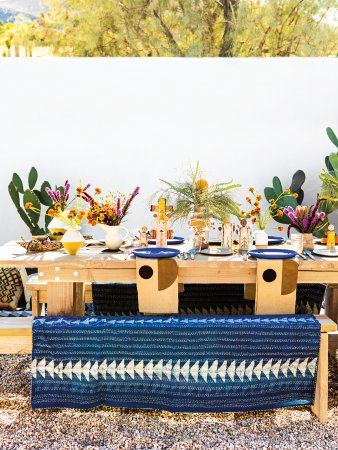 plywood dining table outdoors with block-printed blanket