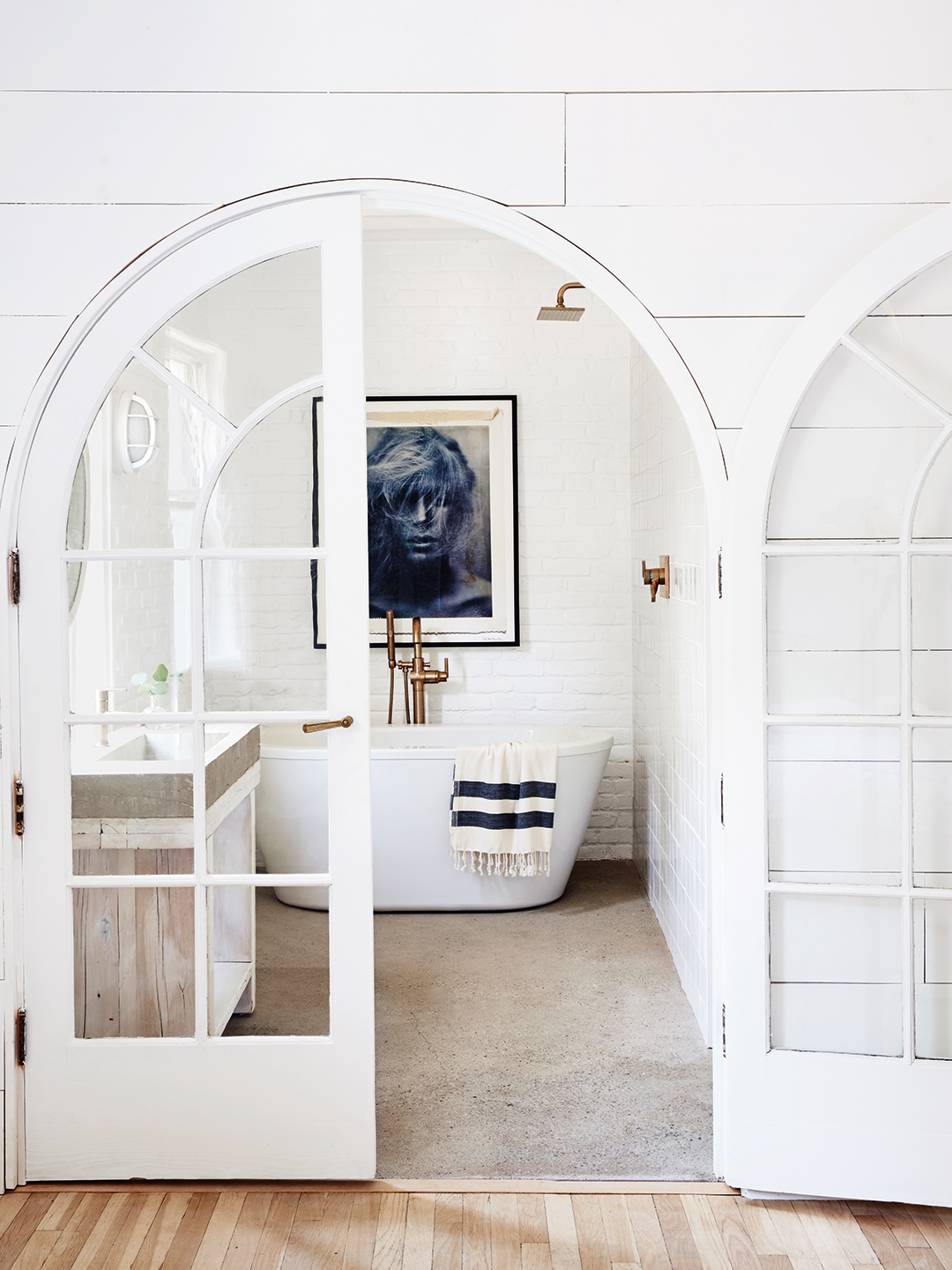 White archway with doors leading to bathtub