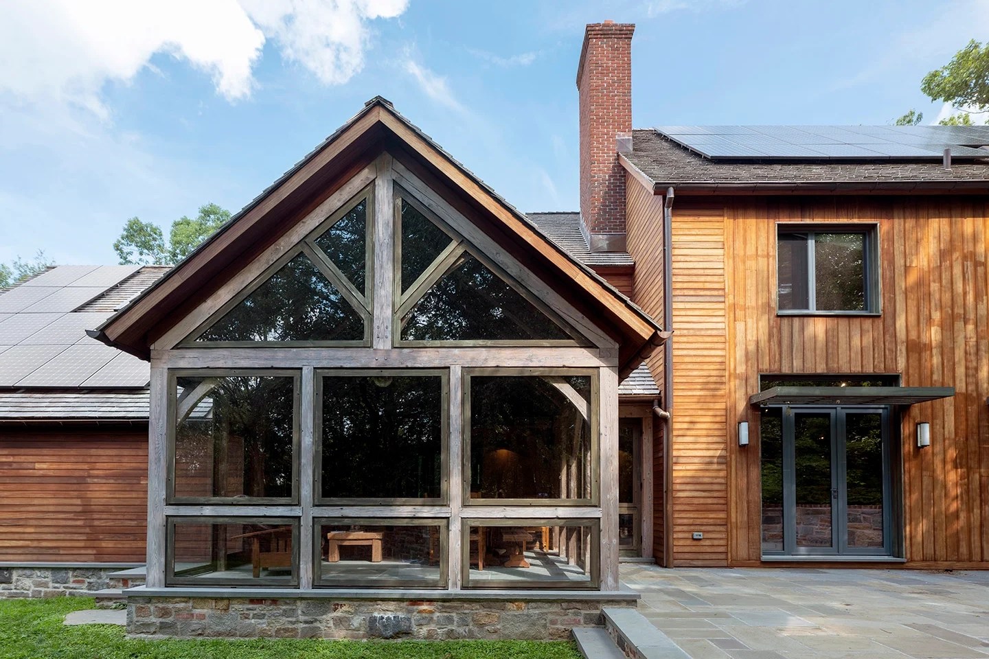 Wood house exterior with floor-to-ceiling windows.