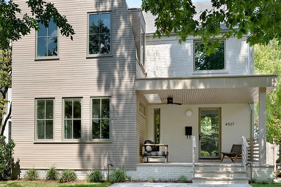 Cream-colored house exterior with trees in front yard.