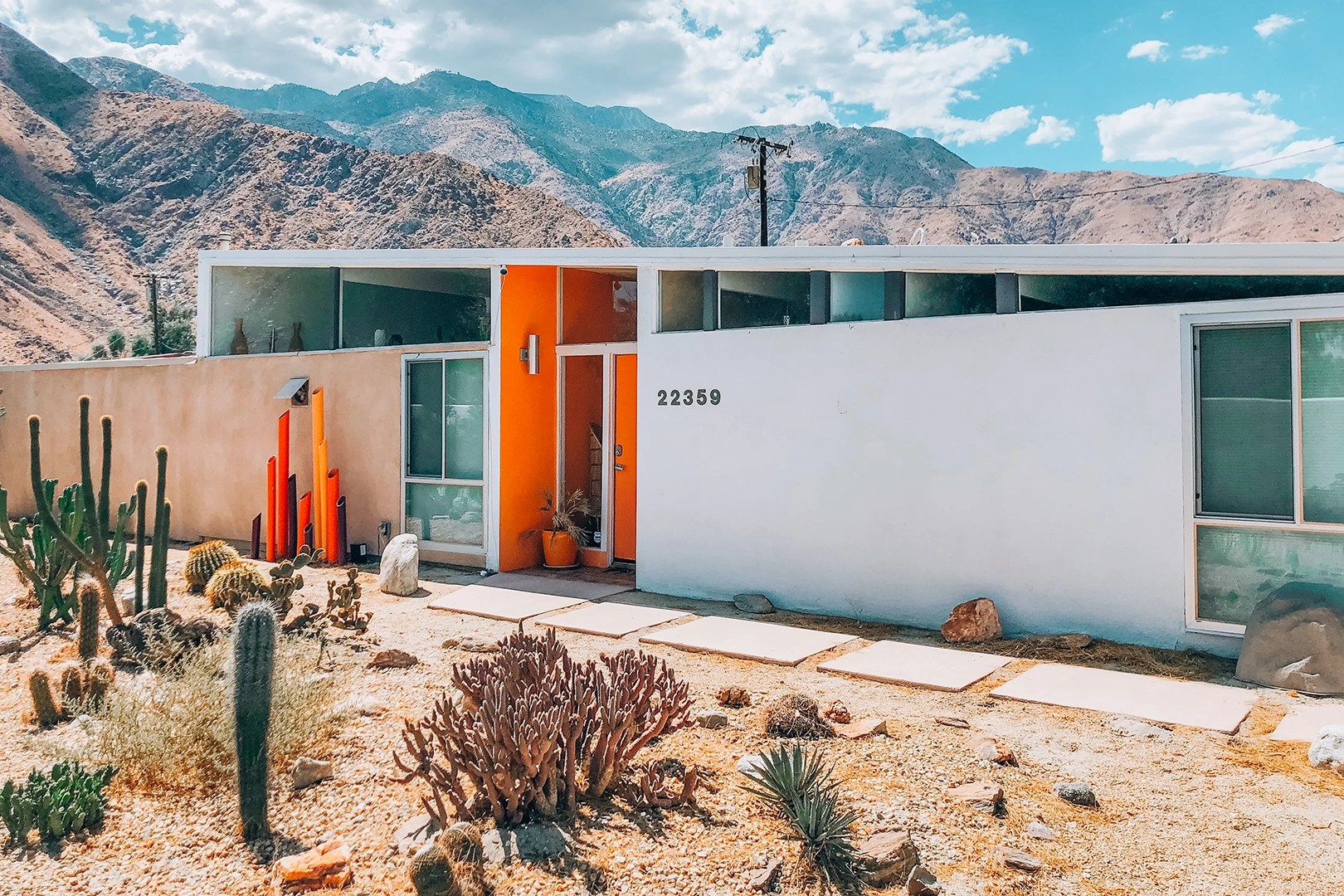 Mid-century desert home exterior with orange door.