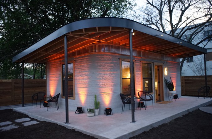 exterior of tiny concrete house with uplighting