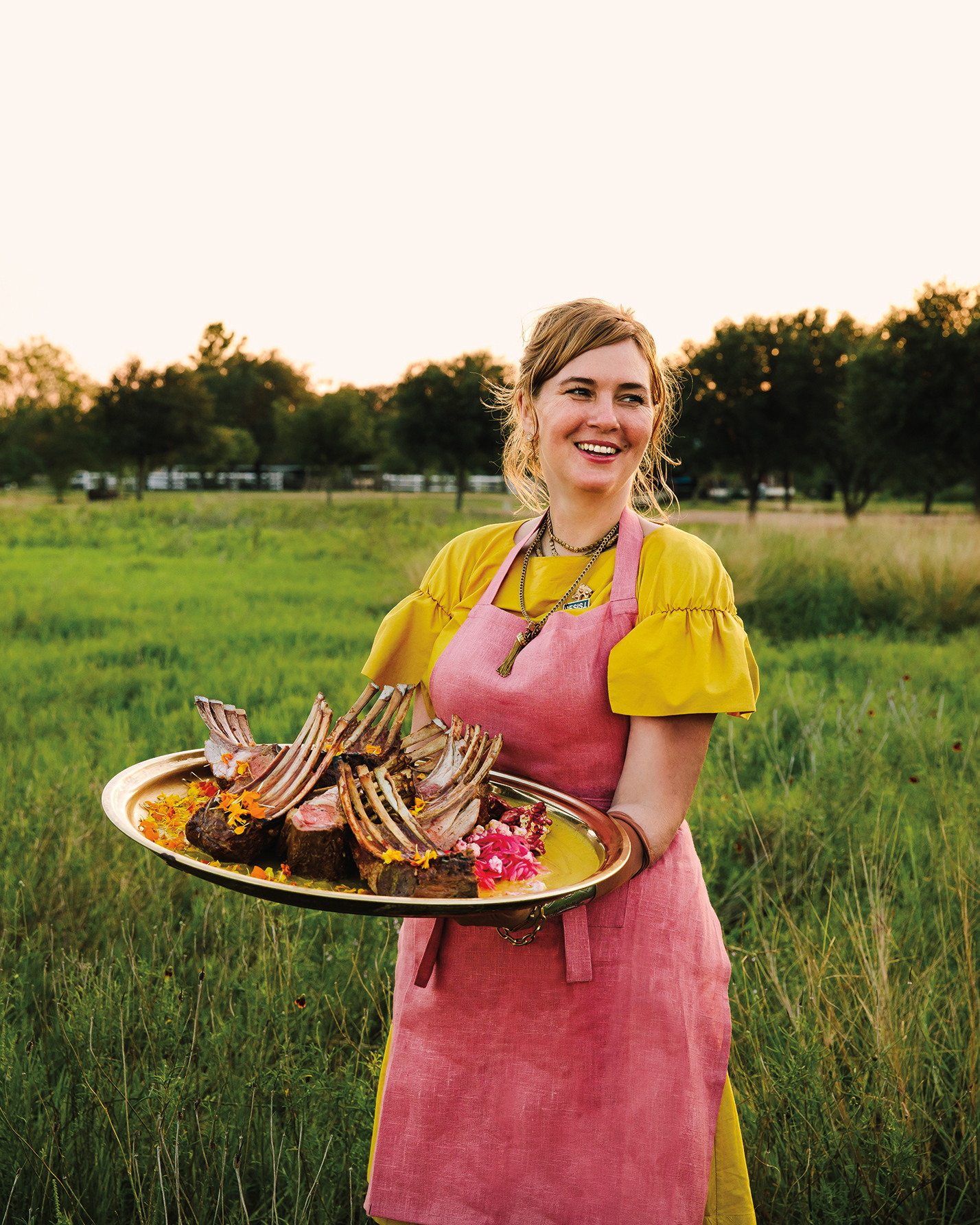 woman holding platter of racks of lamb