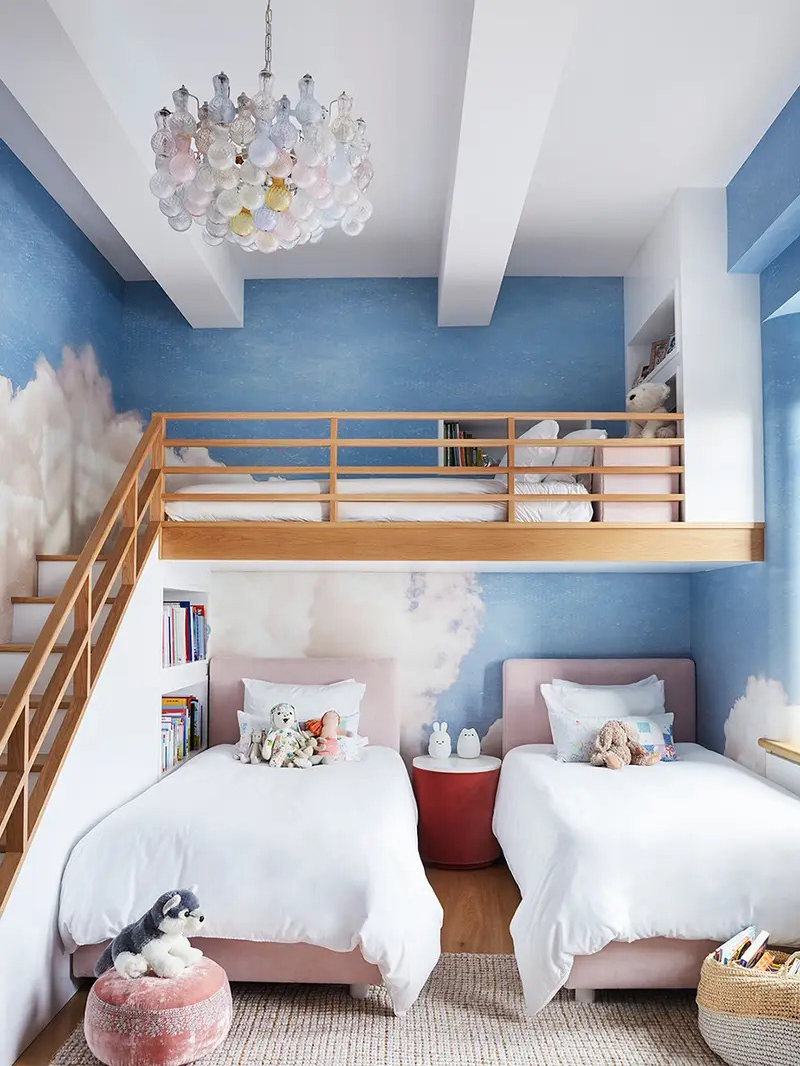 Kids' bedroom with lofted bed and cloudy sky mural painted along back wall.