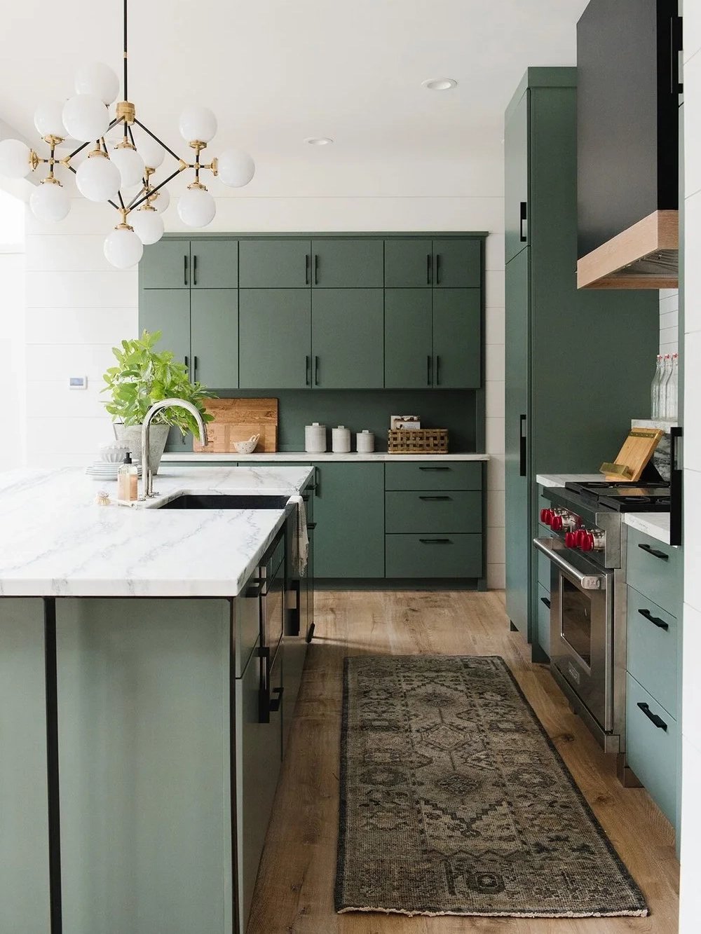 Kitchen with sage green cabinets and carpet on floor.