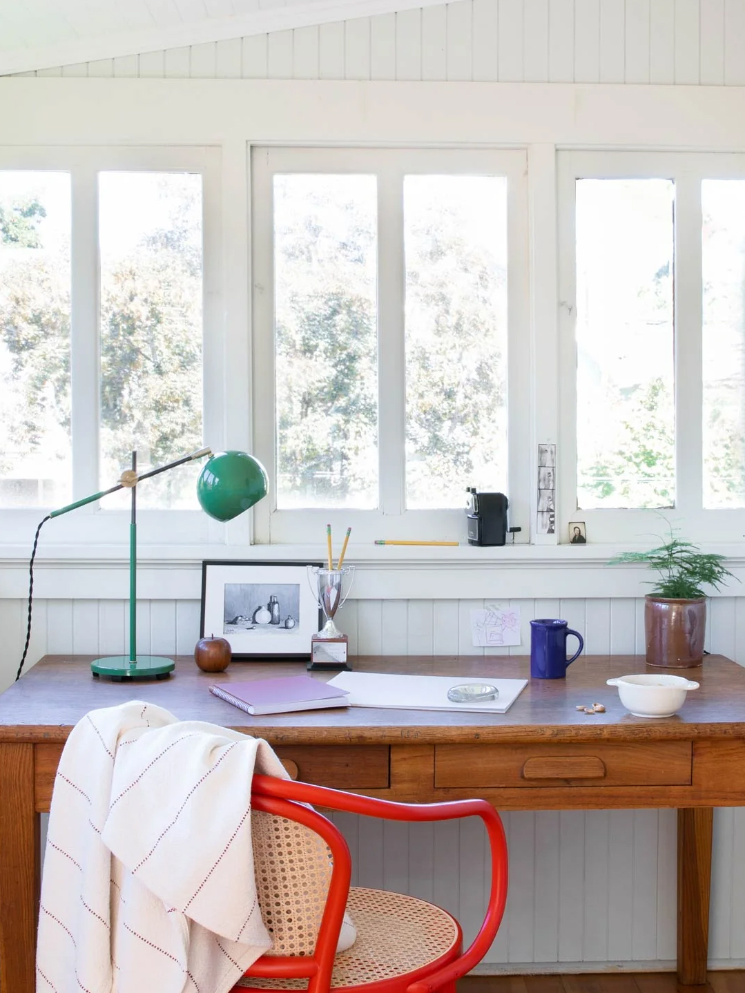 Schoolhouse green desk lamp atop wooden desk in sunlit room. Featuring yellow Word Week design badge and border.