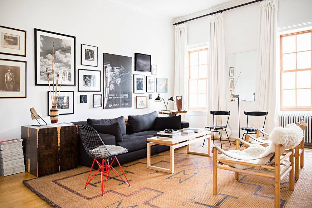 domino magazine white living room with gallery wall and gray sofa