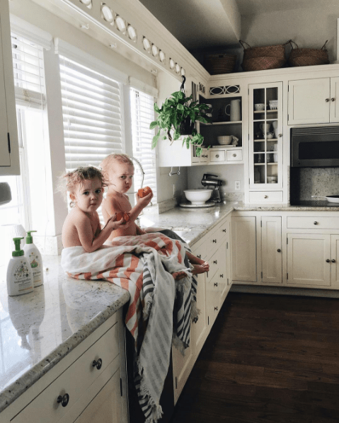 domino magazine white kitchen with gray counters and dark hardwood floors