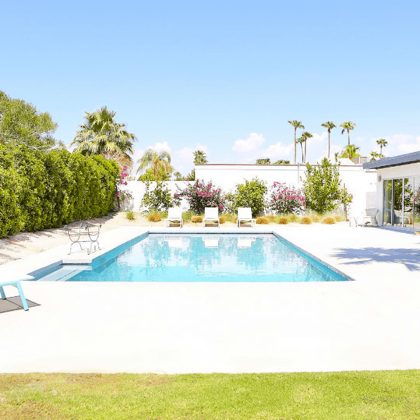 domino magazine square pool with three white chaise lounges