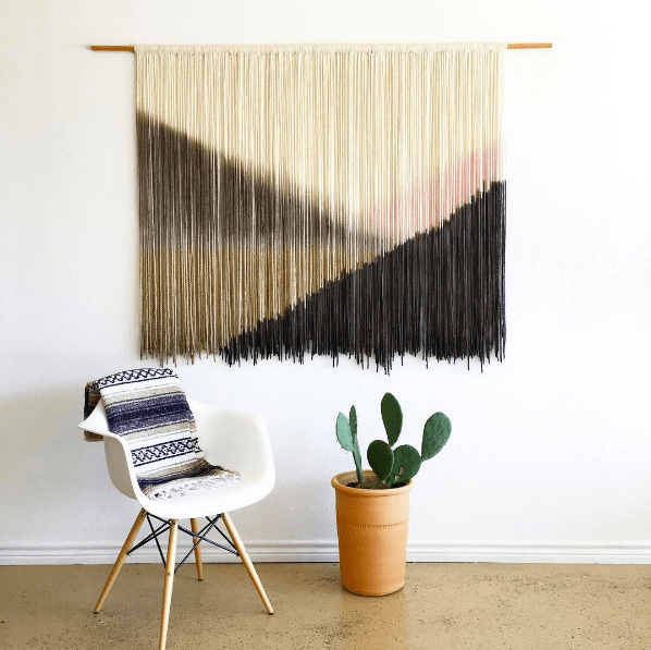 domino magazine white wall with fringe art