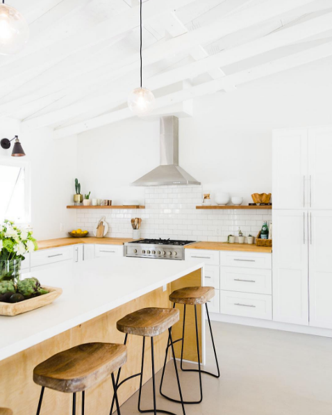 domino magazine white kitchen with raw wood barstools