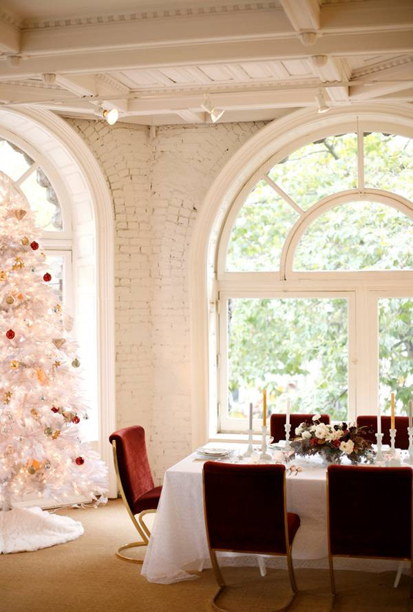 holiday entertaining white room with white christmas tree and red chairs