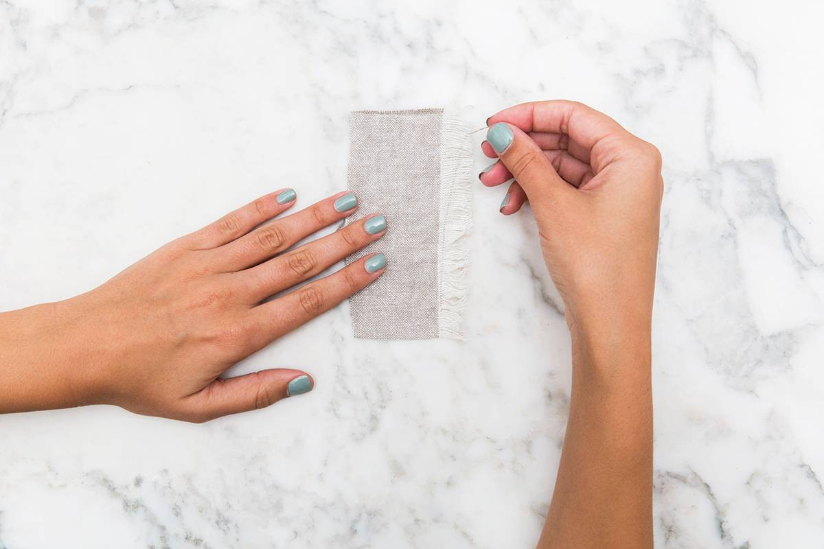 diy pillow tassels fabric on marble with hands