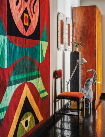 colorful quilt on wall next to orange chair