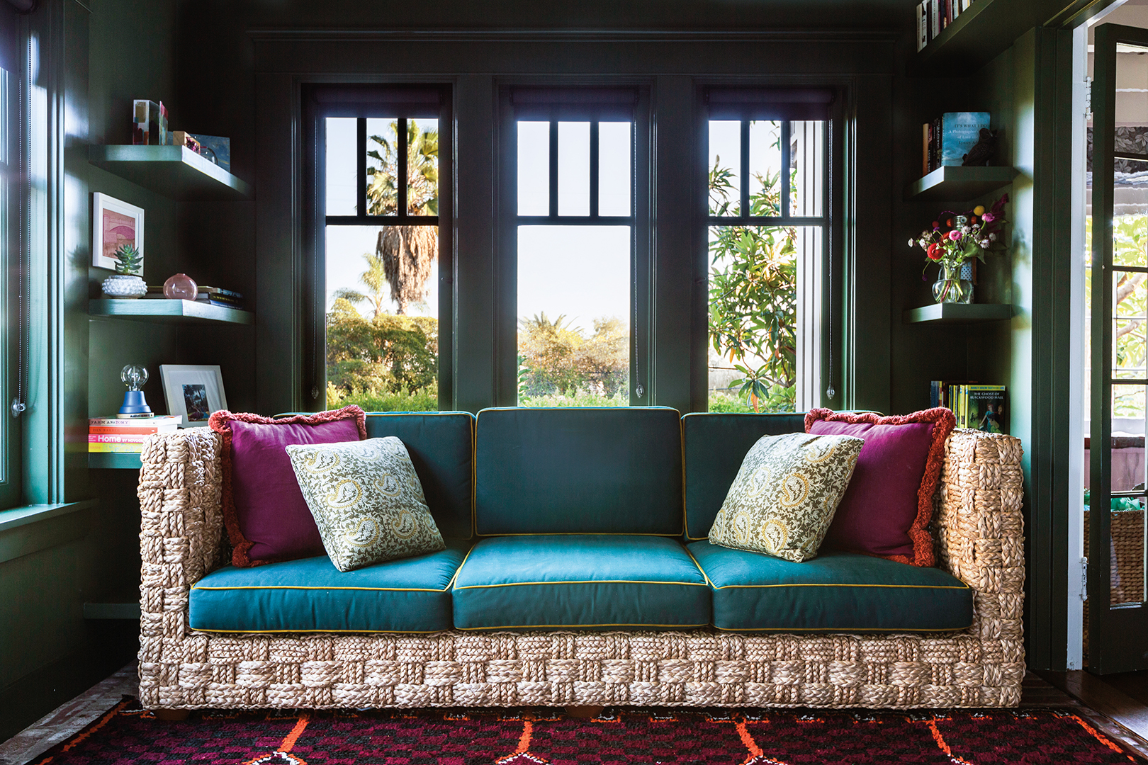 Jewel-toned sofa in front of windows 