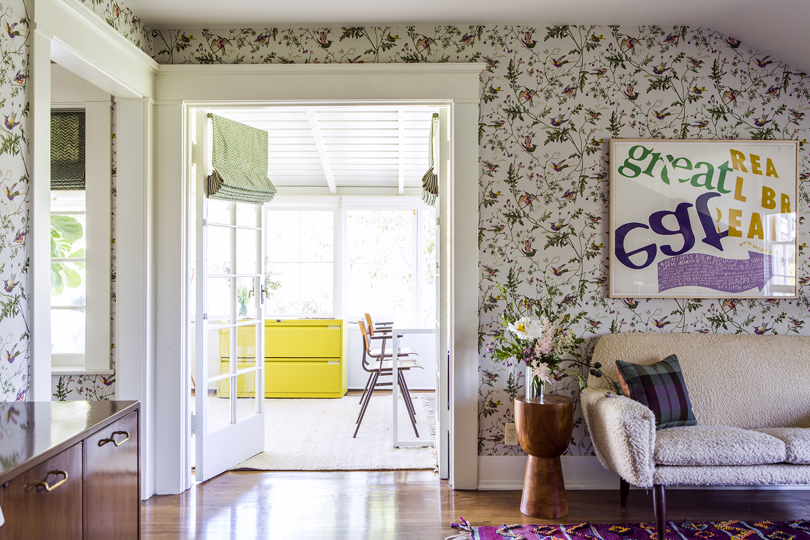 wallpapered room looking into a sunroom