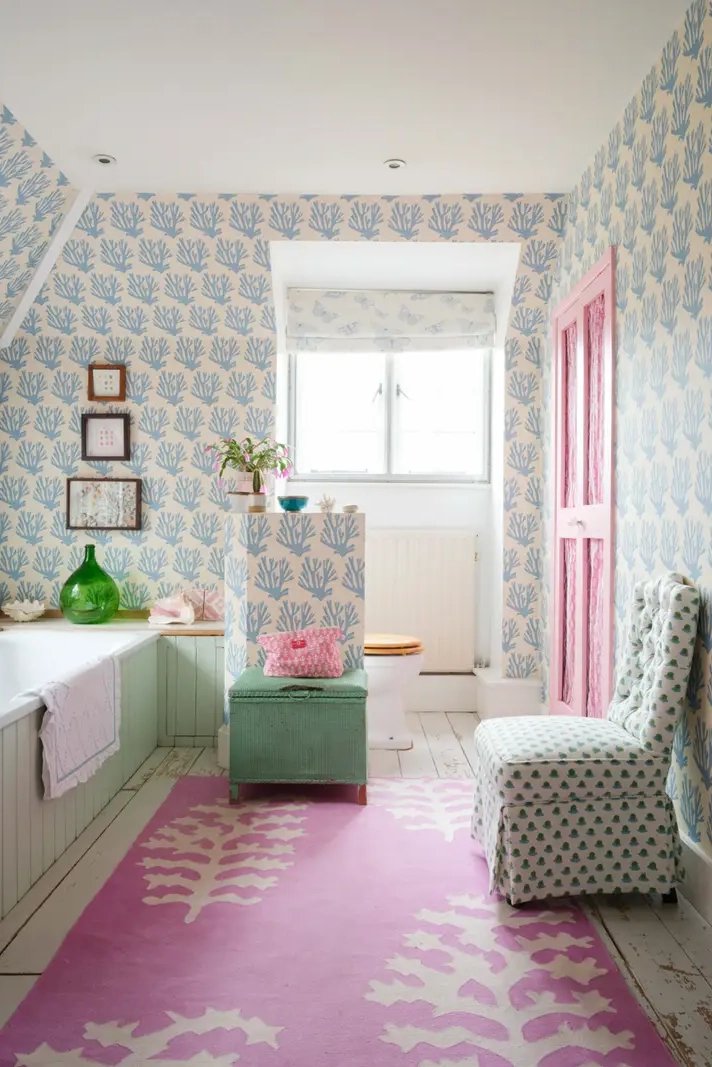 Bathroom with pink carpet, blue wallpaper, and mint green bathtub.