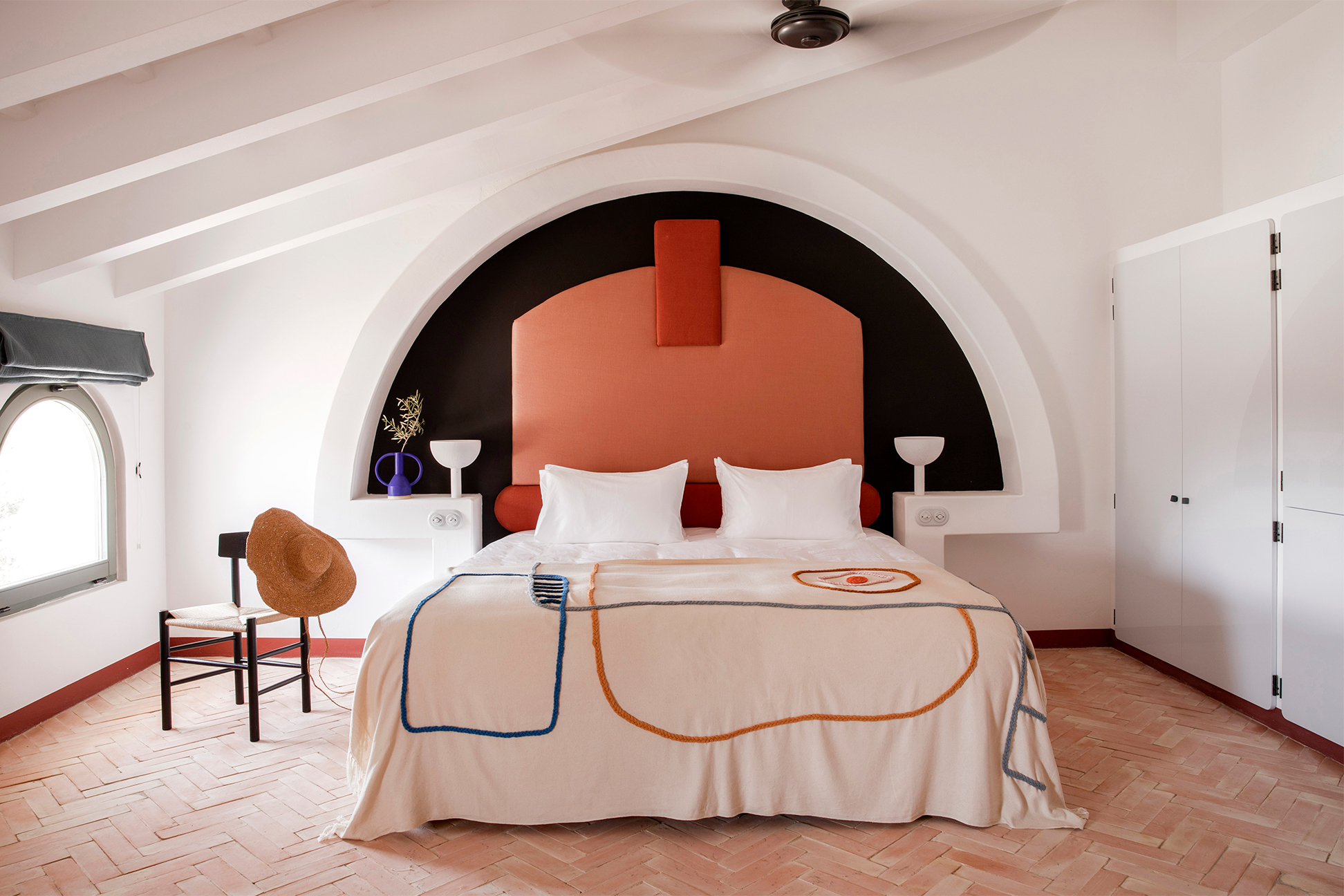 hotel bedroom with red and black headboard and graphic blanket