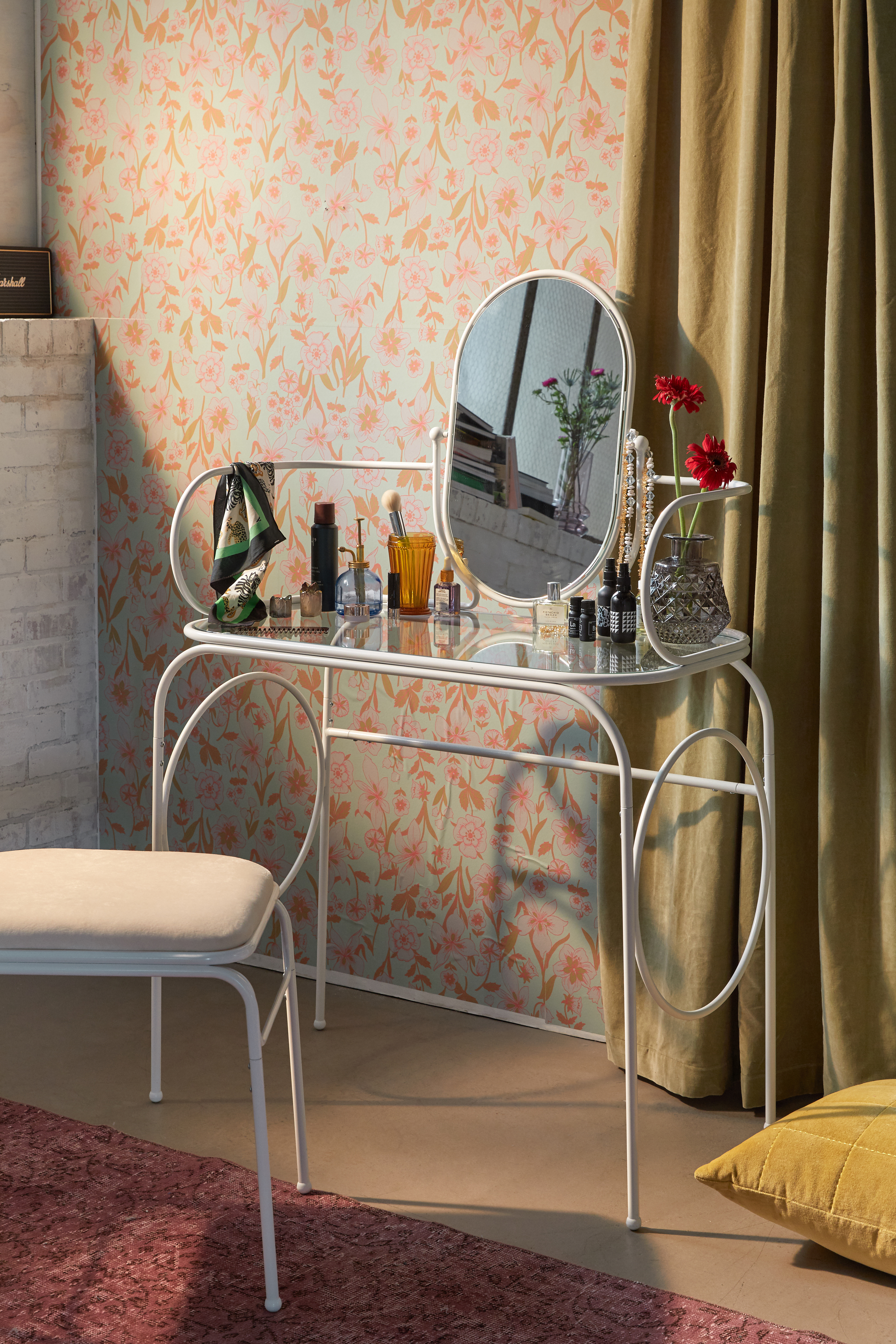 A white vanity made from bent steel tubing with matching mirror and stool
