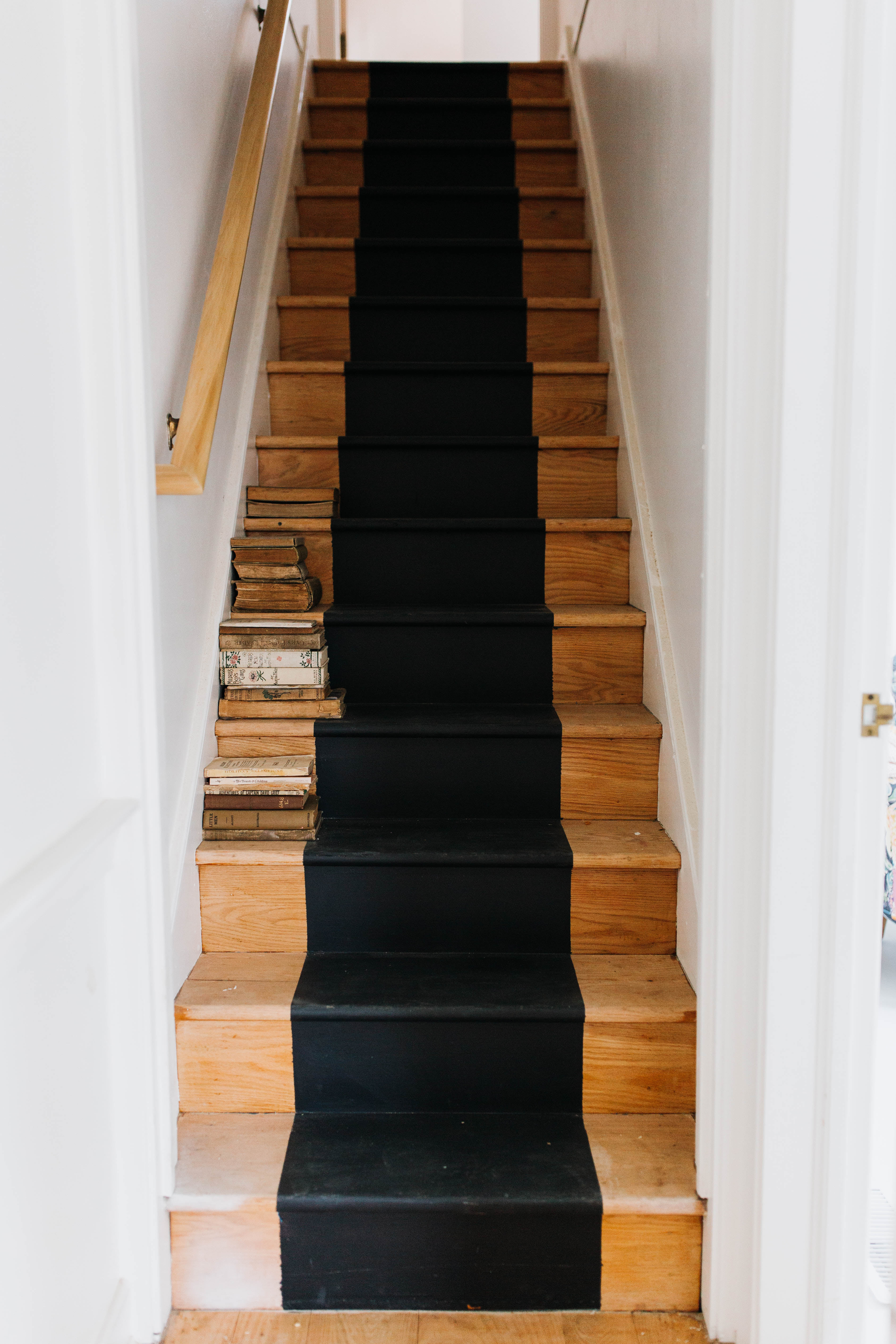 narrow wood stairs with black stripe down the center