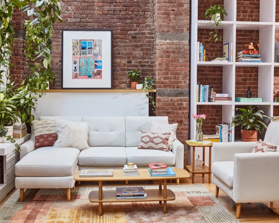 Living room with light sofa and brick walls.