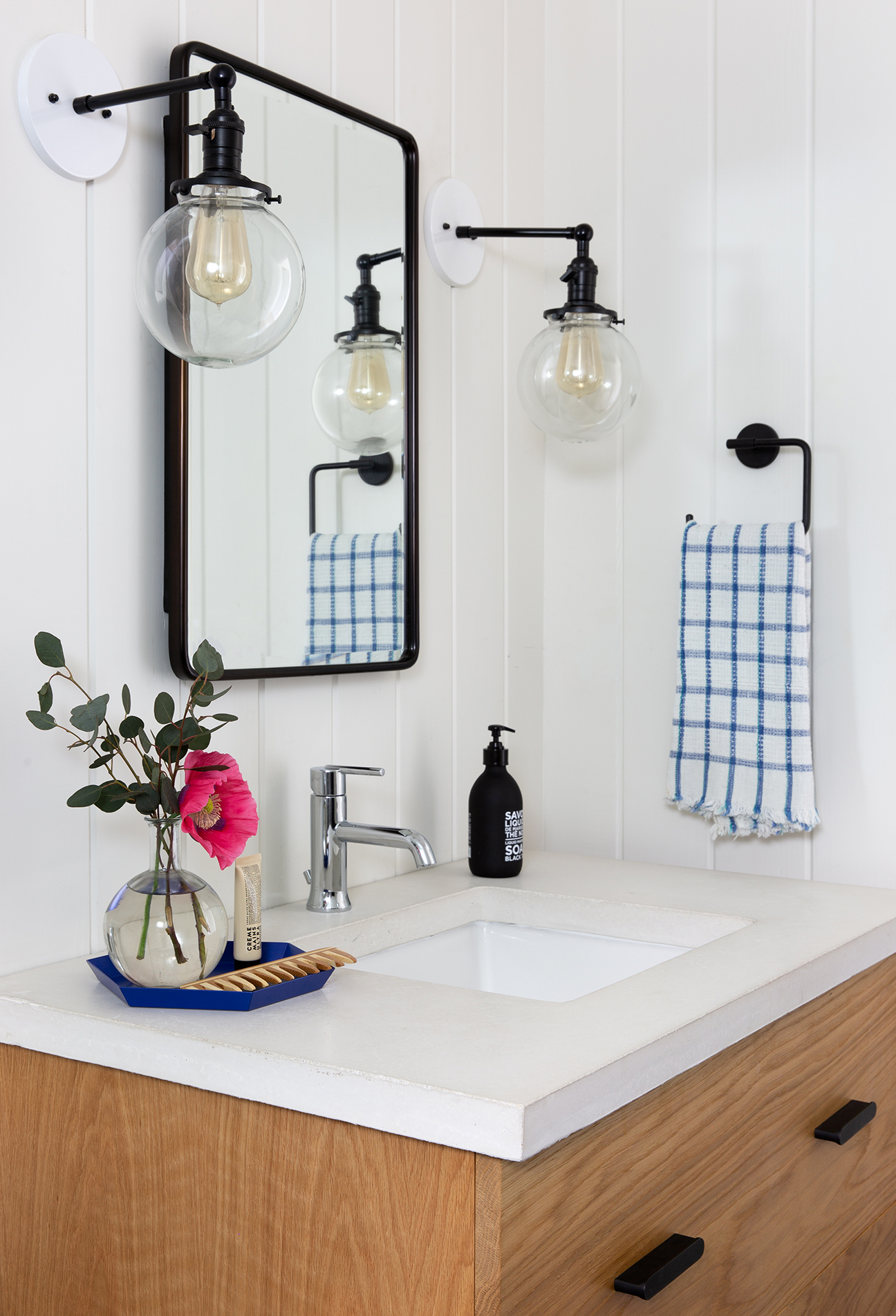 Bathroom sink with large bulb sconces.