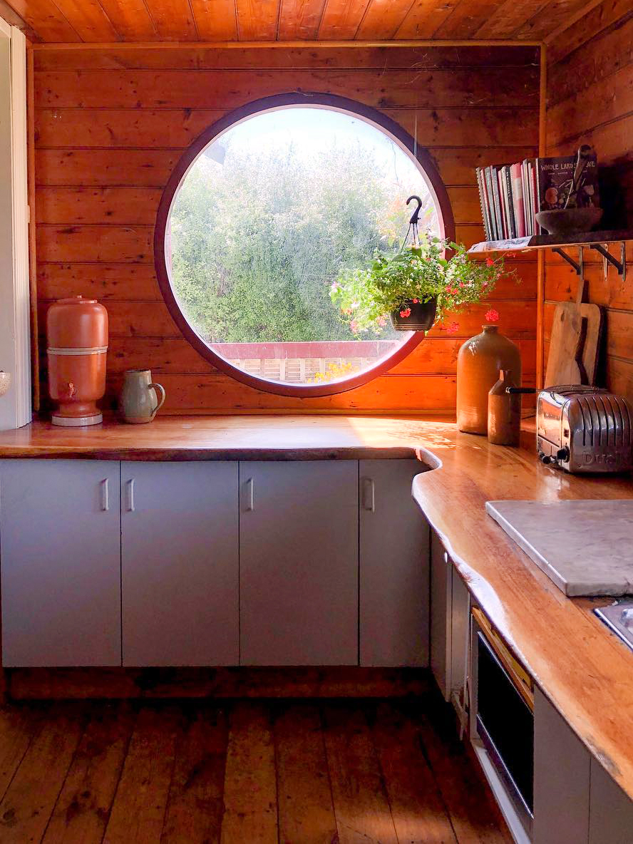 cozy cabin kitchen wiht a round window