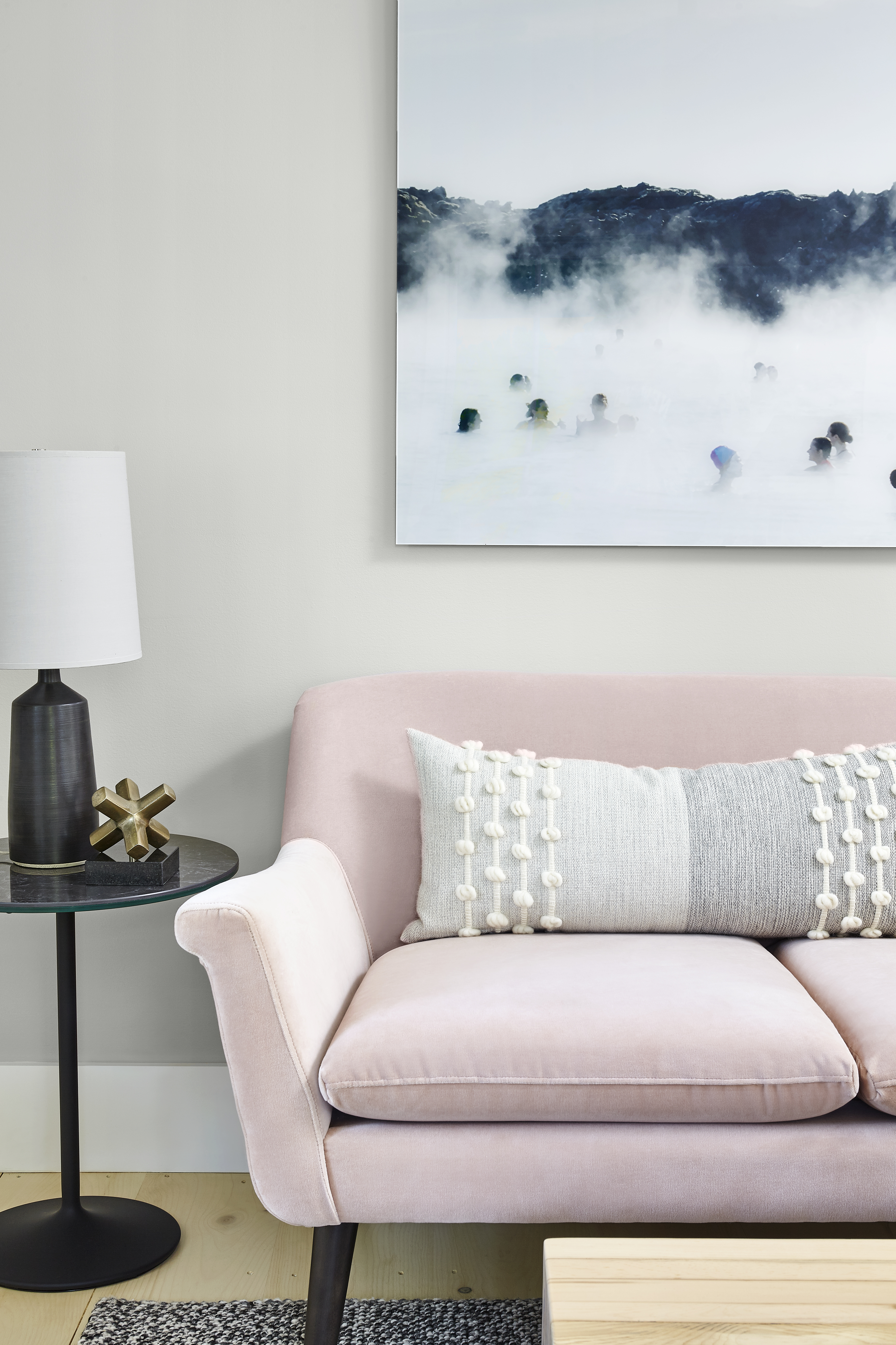 Pink sofa with photography above.