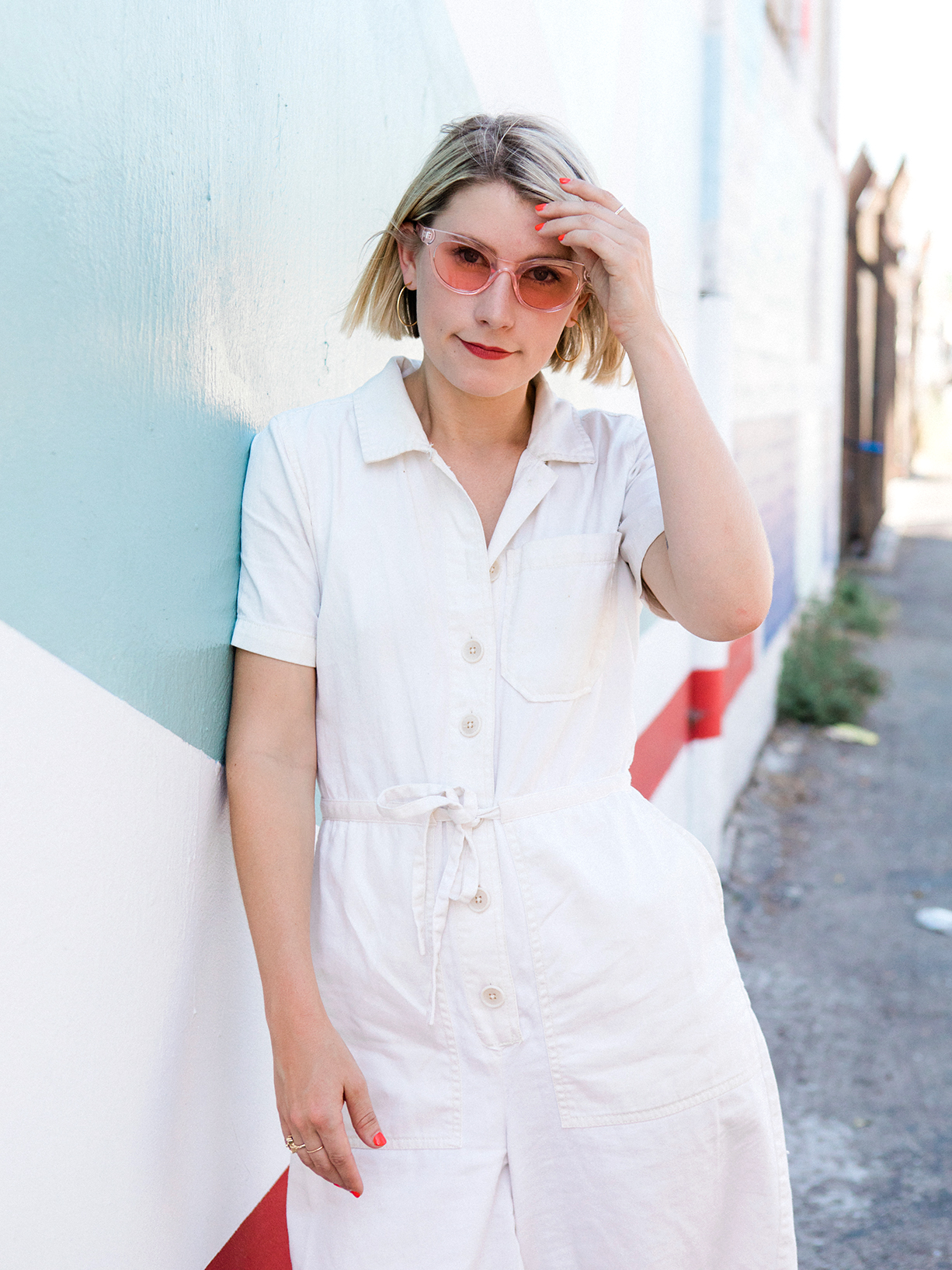 abby pendergrast leaning against a blue exterior wall