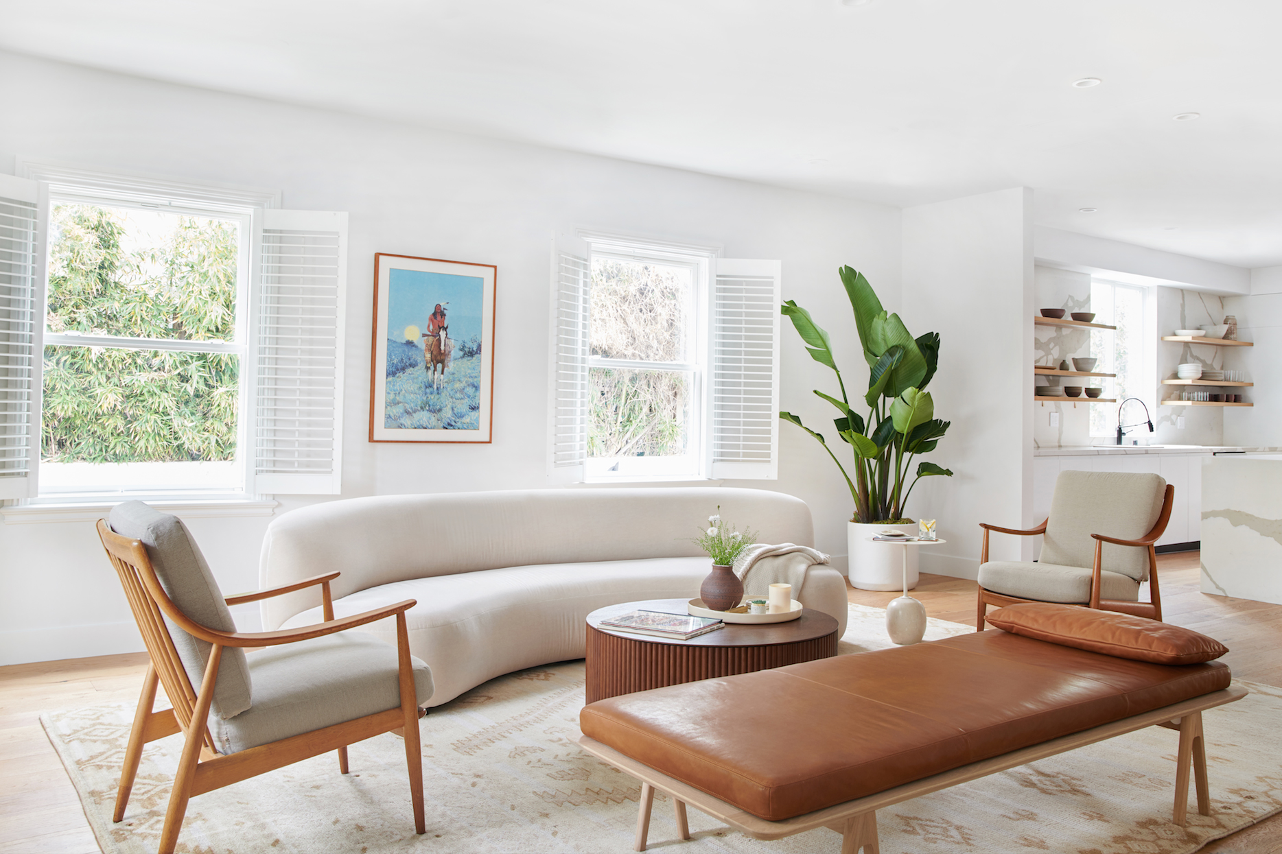 sitting room with leather daybed and curved white sofa