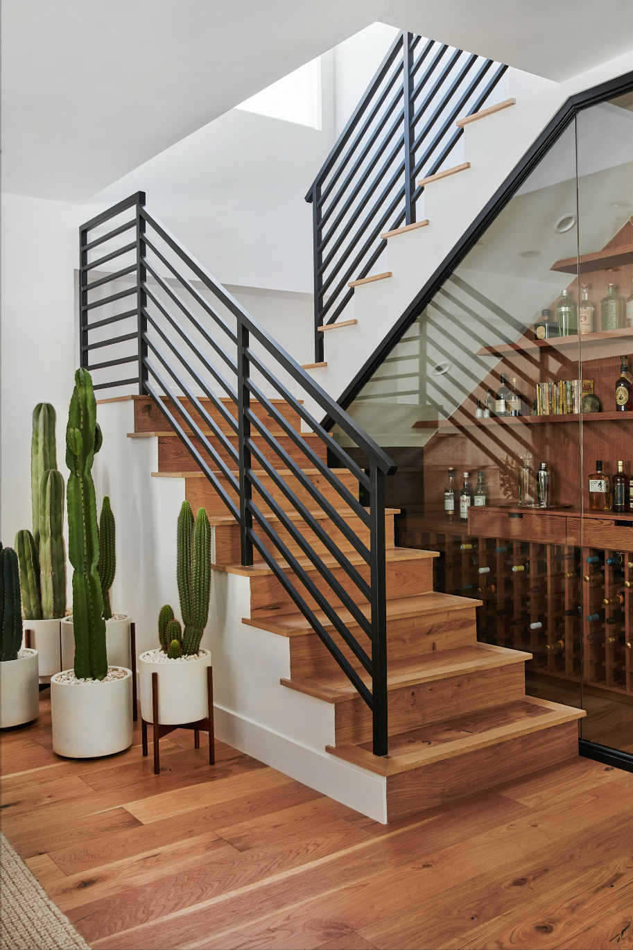 modern staircase with a glass enclosed bar underneath