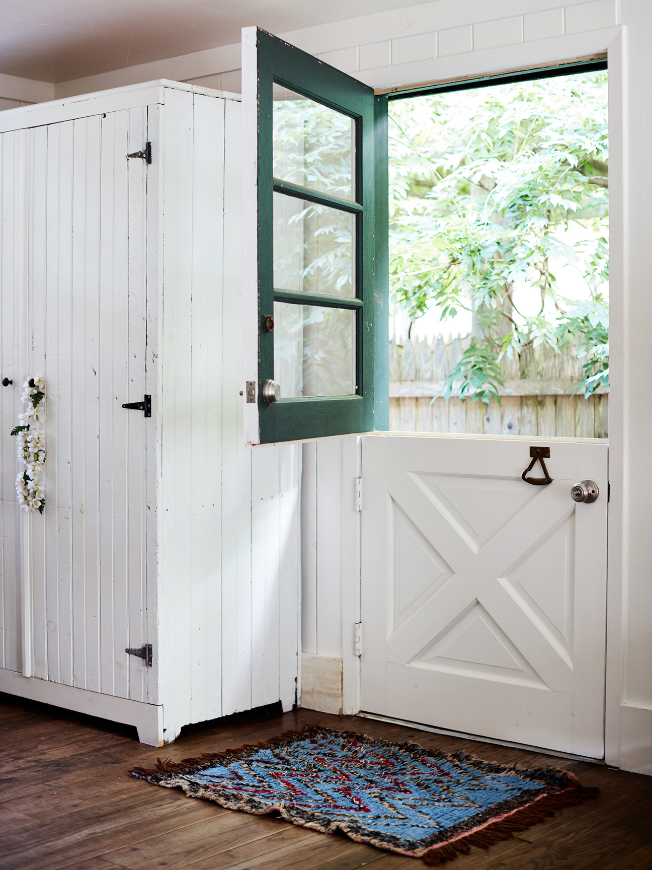 indoor view of a half open dutch door with a green top