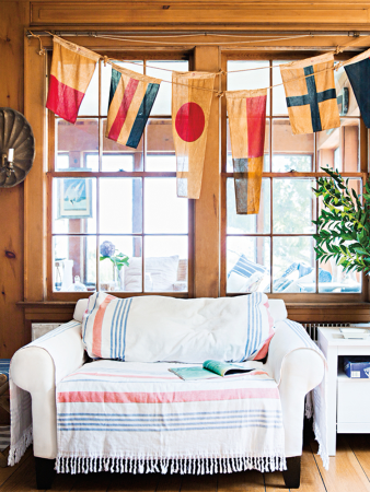 White two-seater sofa in a wood-paneled room.