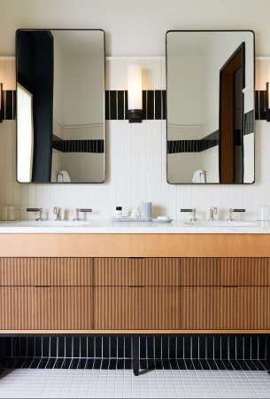 wood bathroom vanity surrounded by marble walls and counter