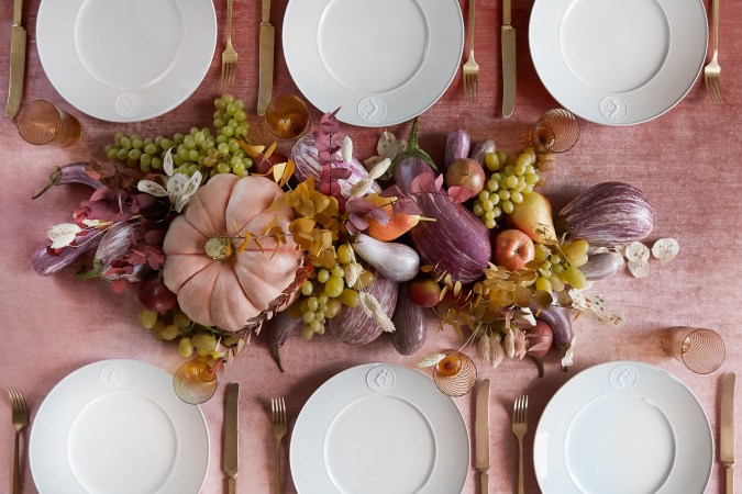 birds eye shot of white plates on a pink velvet table