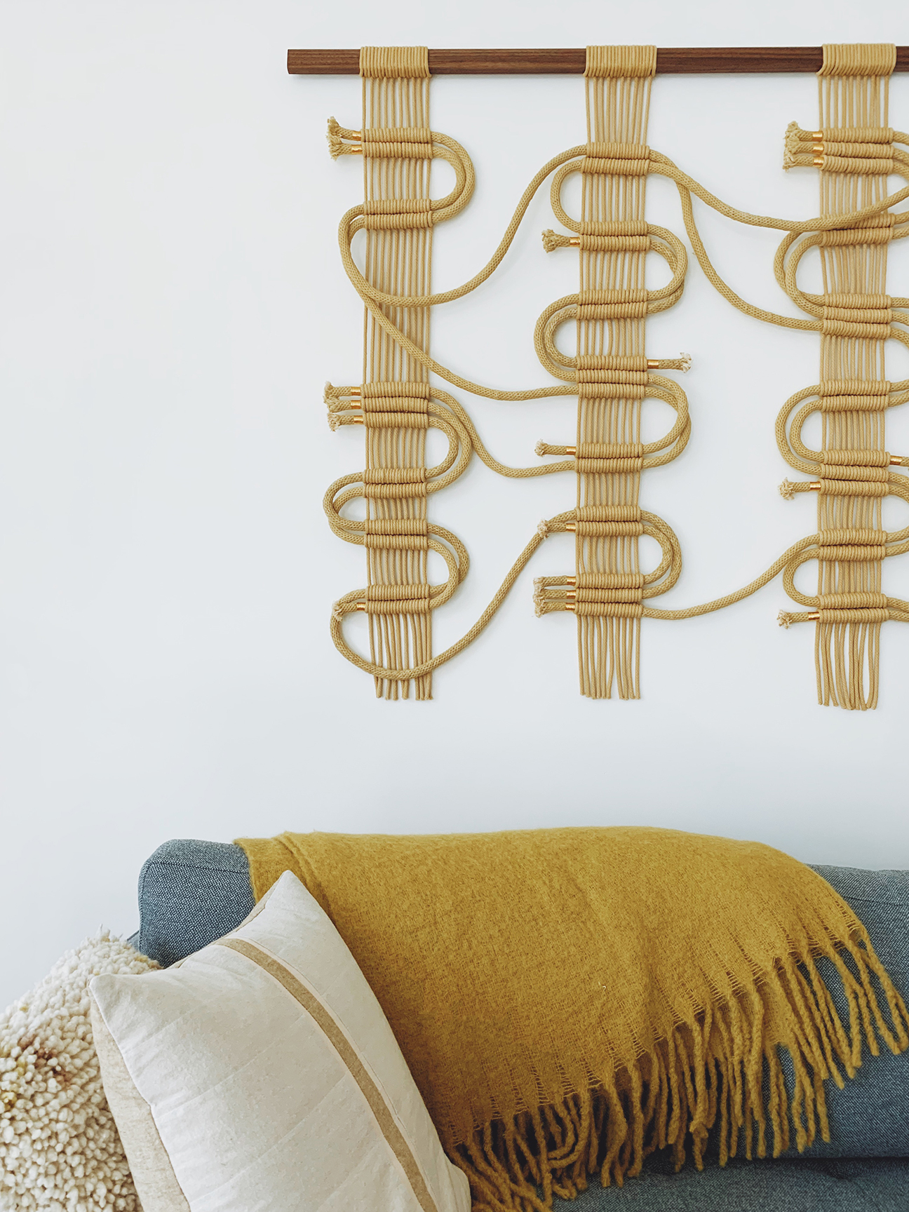 rope wall hanging and a gray sofa