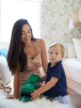 laurel galucci sitting on a sofa looking at her son playing