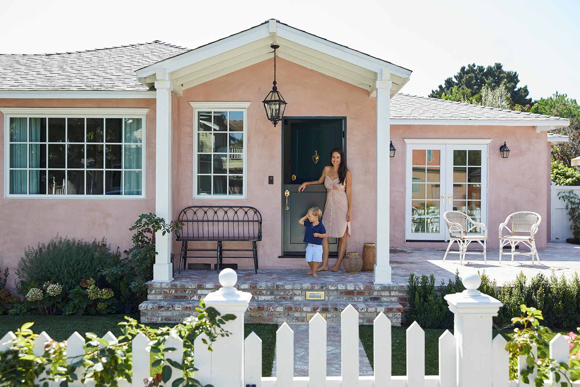 laurel and her son walking out of their pink cottage