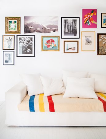 white sofa with bottom cushion covered in blanket