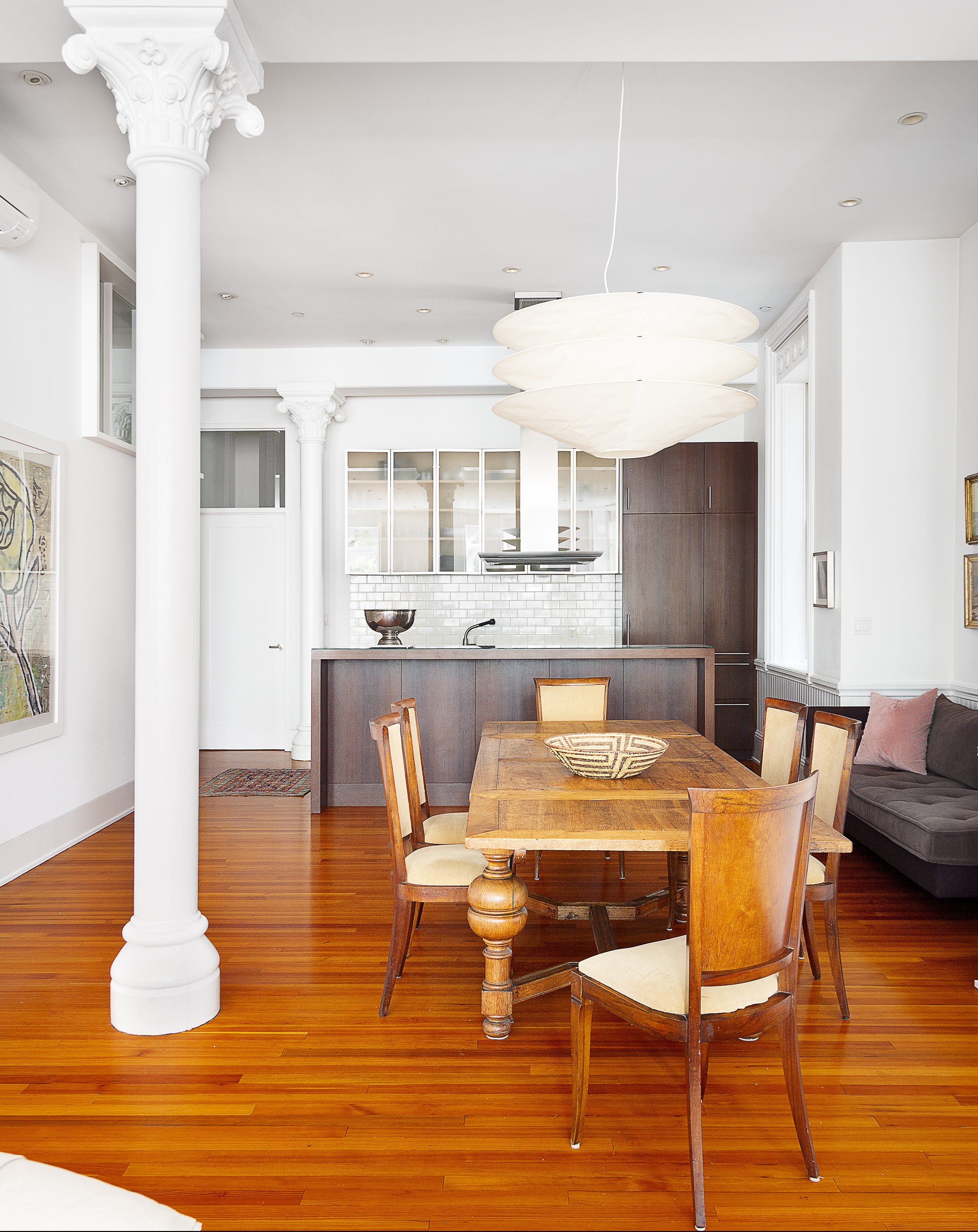 white . kitchen with farmhosue dining table and a column