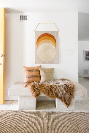 Entryway with concrete bench and wall hanging