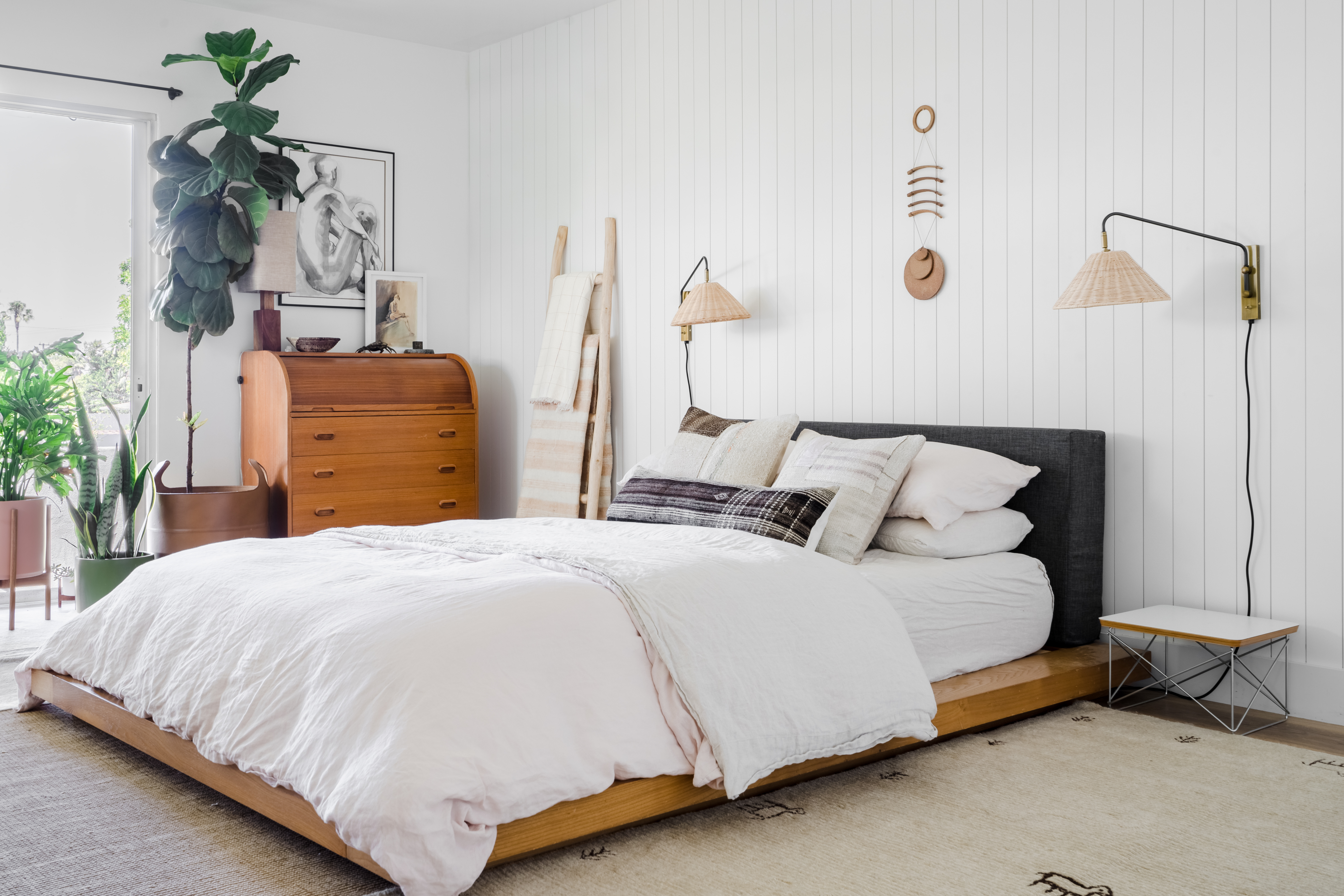 Bedroom with shiplap walls and rattan sconces