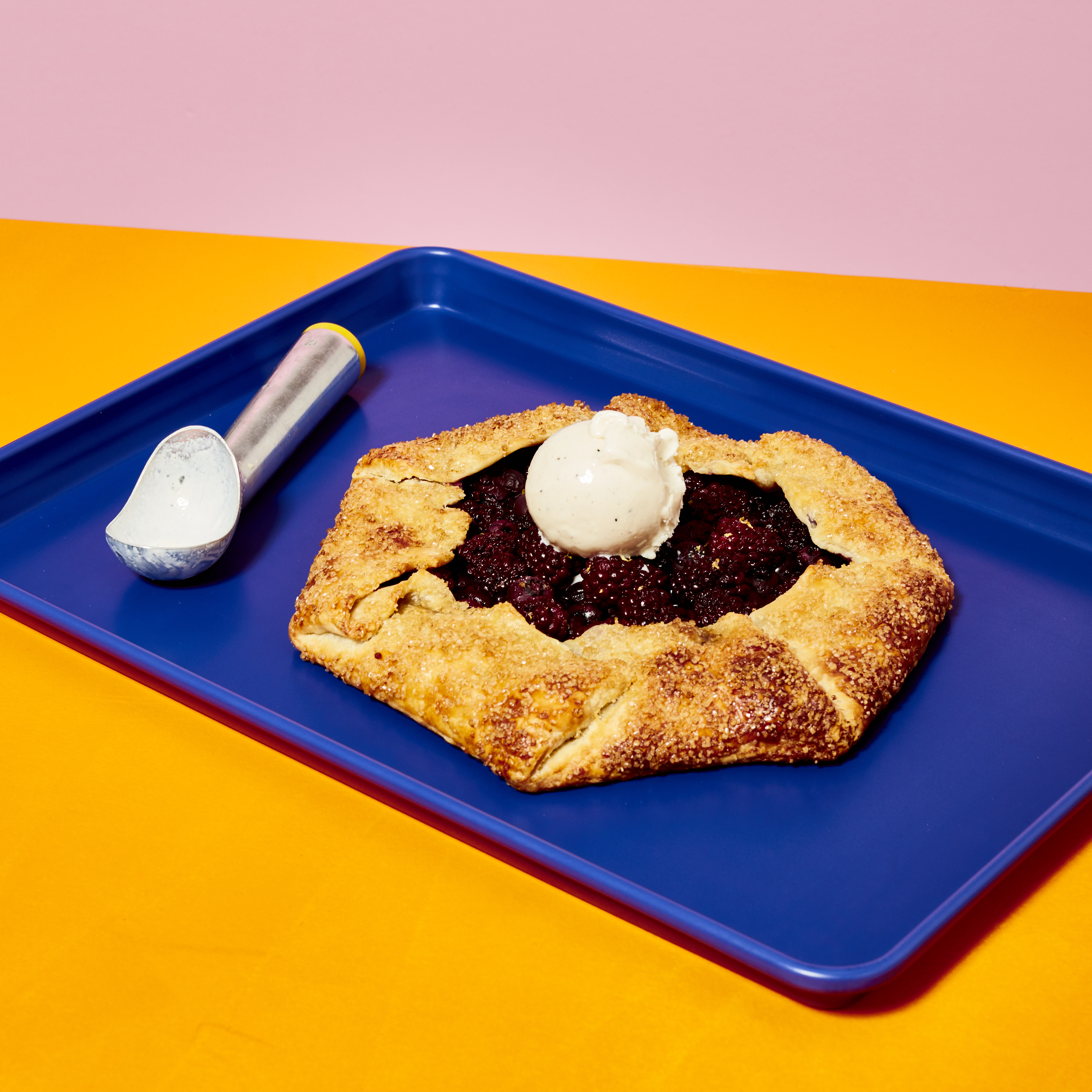 Berry galette on top of blue Great Jones sheet pan