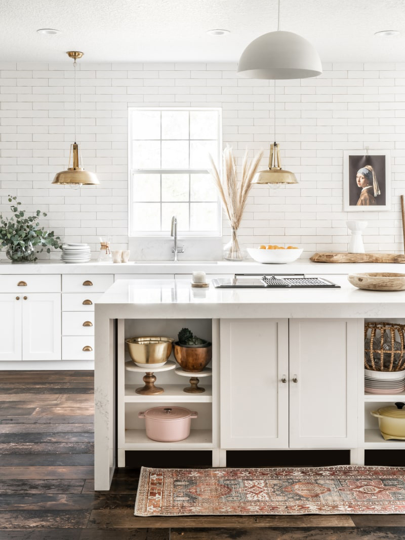 brass wall sconces and white kitchen with subway tile