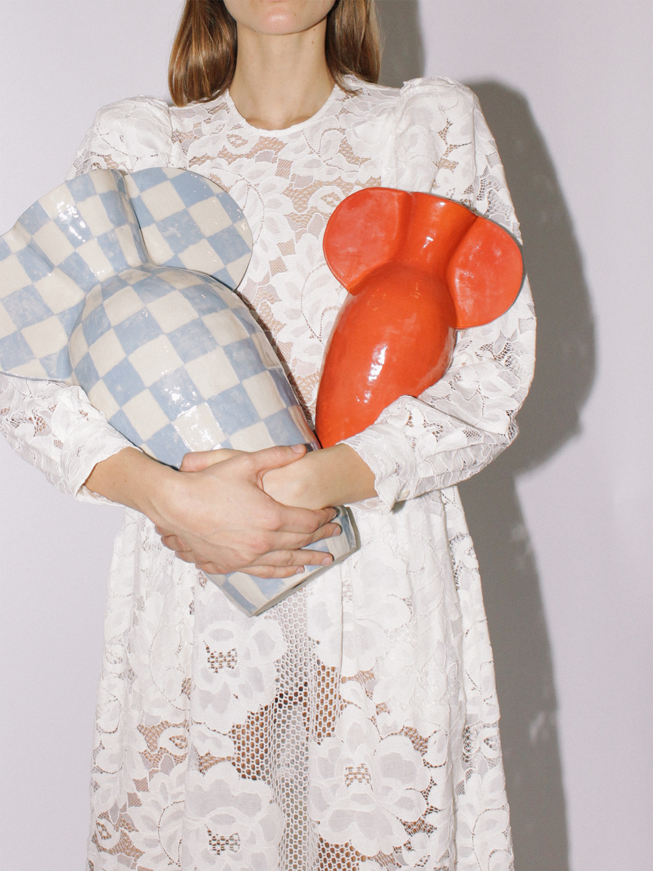 person in white dress holding vases